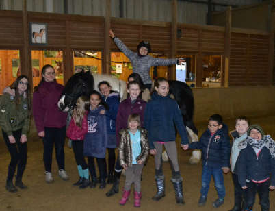 photo d'un groupe mixte d'enfant et d'ado dans la piste interieur du manège le mont-garni